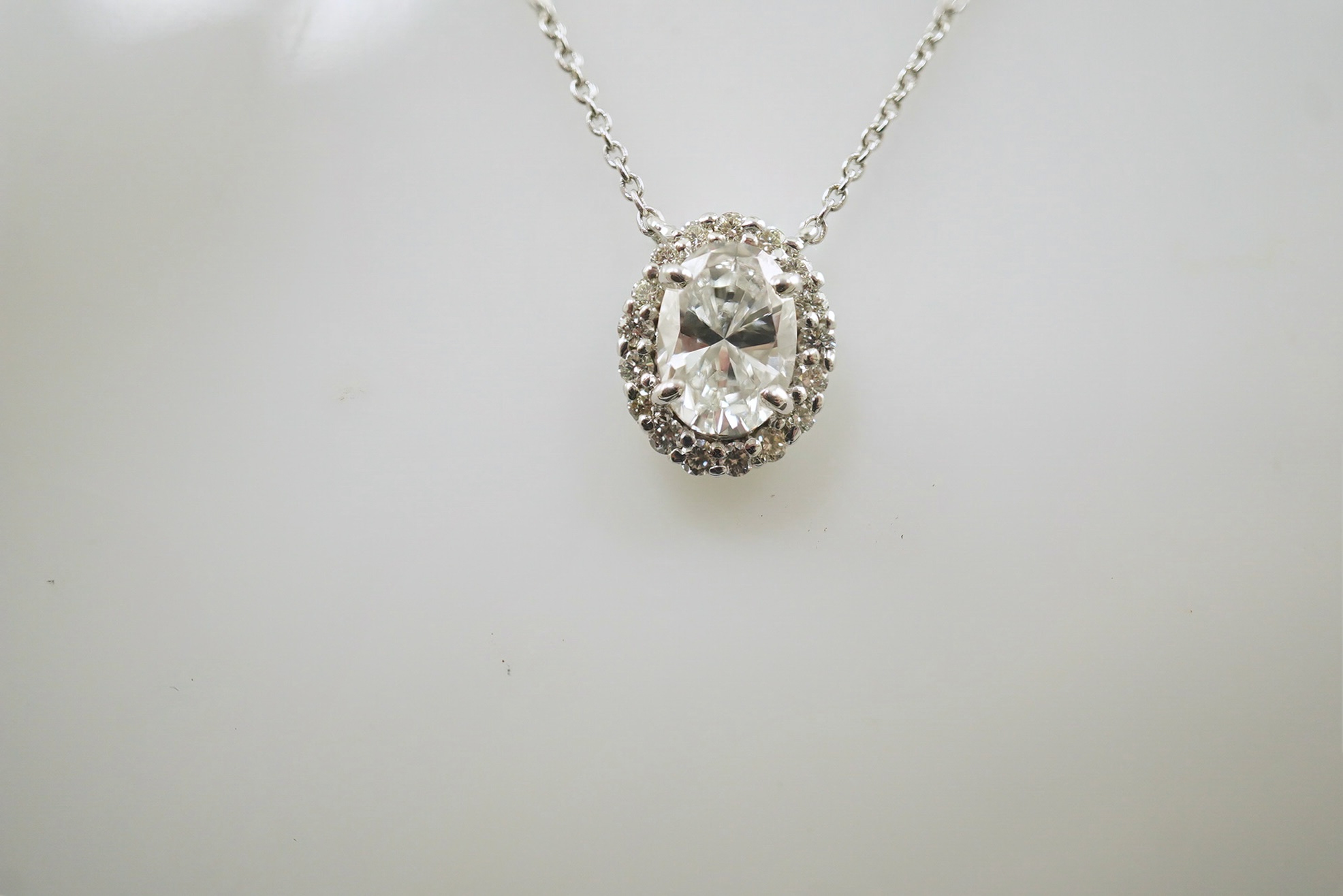 A modern 18k white gold and solitaire oval brilliant cut diamond set pendant necklace